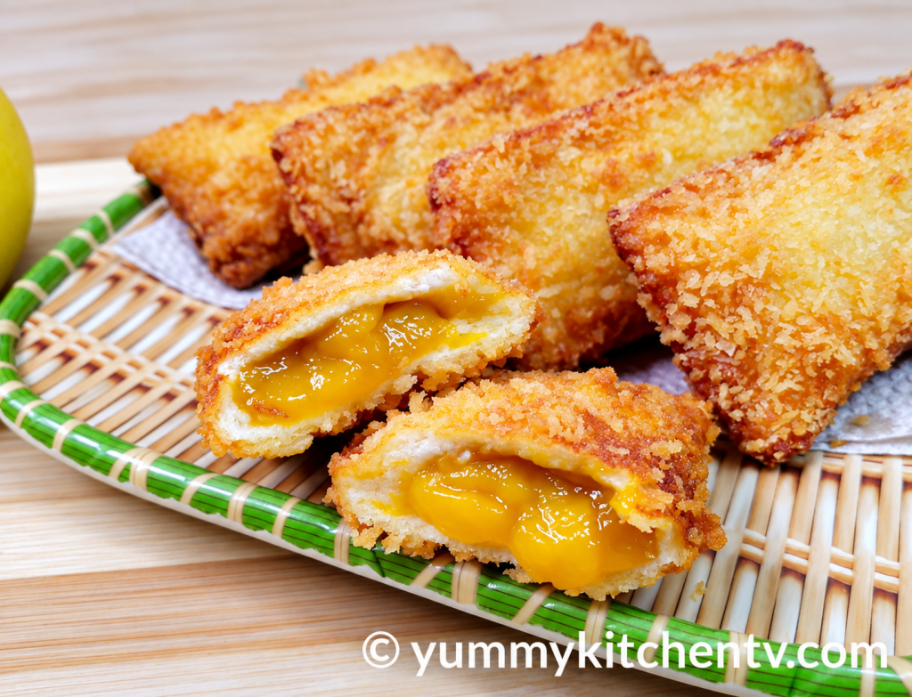 Crispy Mango Bread Pie filled with sweet mango filling, golden brown and served on a woven tray.